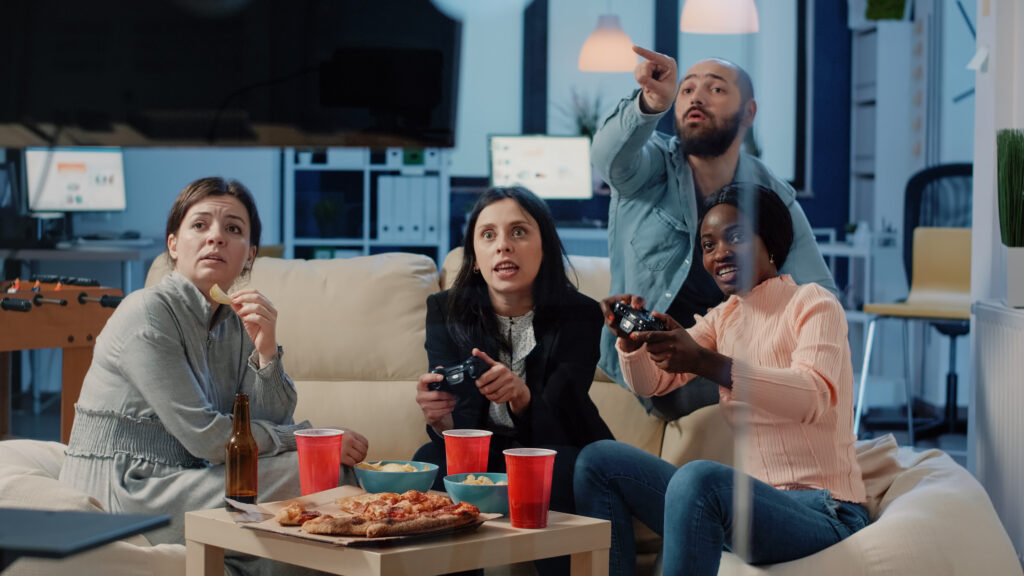 Four friends playing video games at home